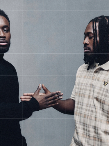 Two men wearing Lyle and Scott standing face to face with a grid overlay on a gray background